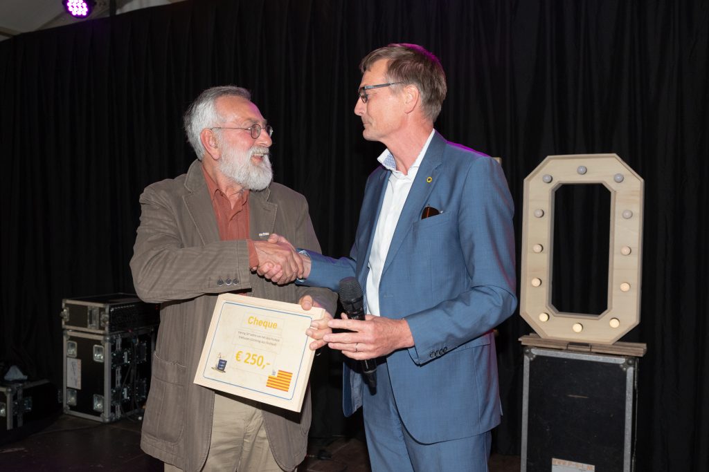 Wethouder Win Bijman overhandigt een cheque aan het bestuur van Stichting Jazz Festival Enkhuizen