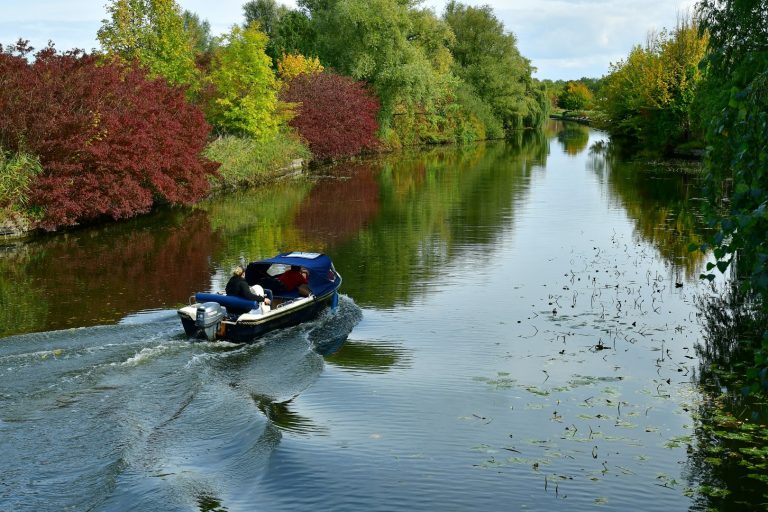Op de afbeelding is een bootje te zien die door het Streekbos vaart.
