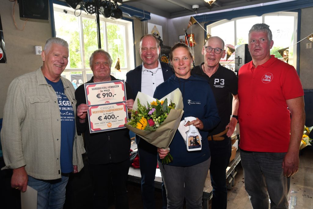 De burgemeester staat met de winnaars op de foto.
