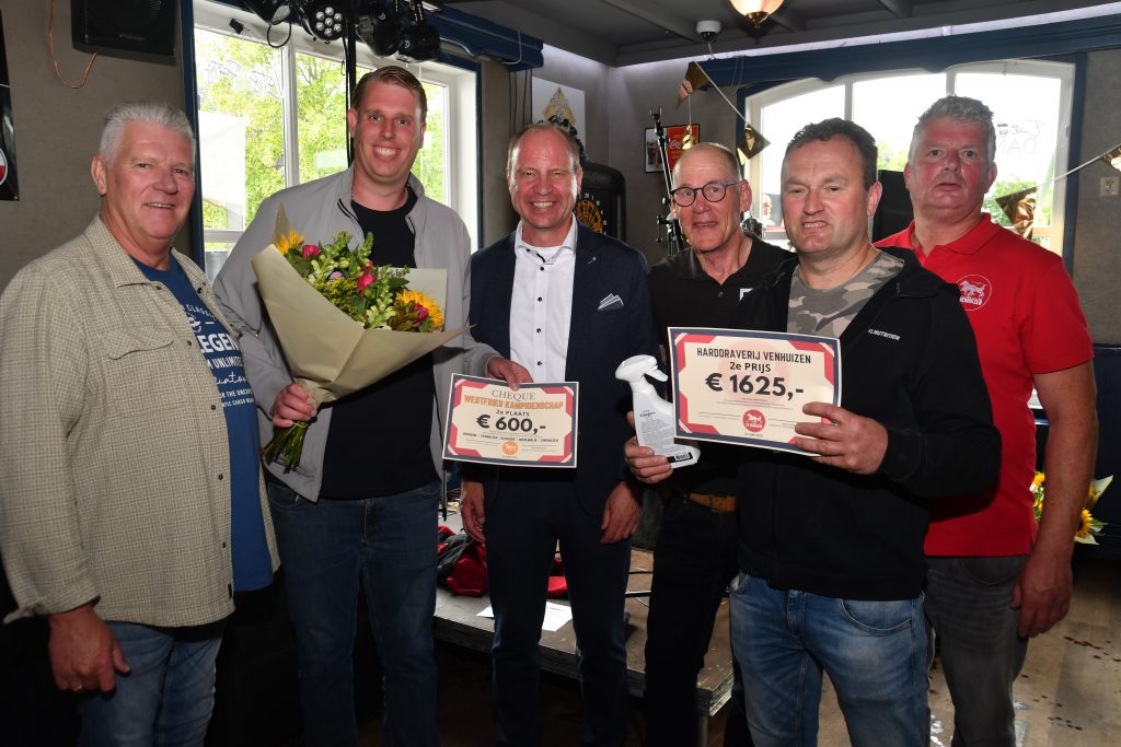 De burgemeester staat met de winnaars op de foto.