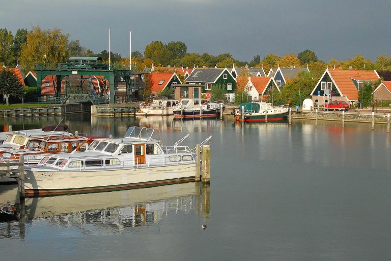 De Broekerhaven: linksvoor een wit moterscheepje. Op de achtergrond de huizen met oranje daken