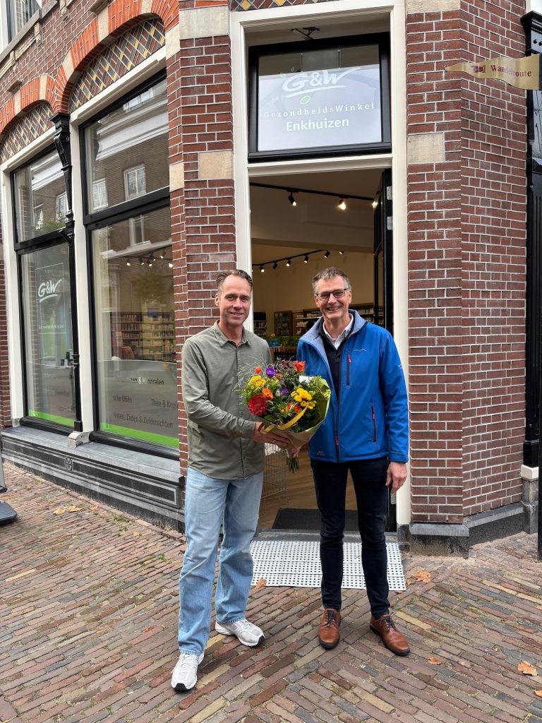 De ondernemer en wethouder Win Bijman staan voor het nieuwe pand aan Westerstraat 114