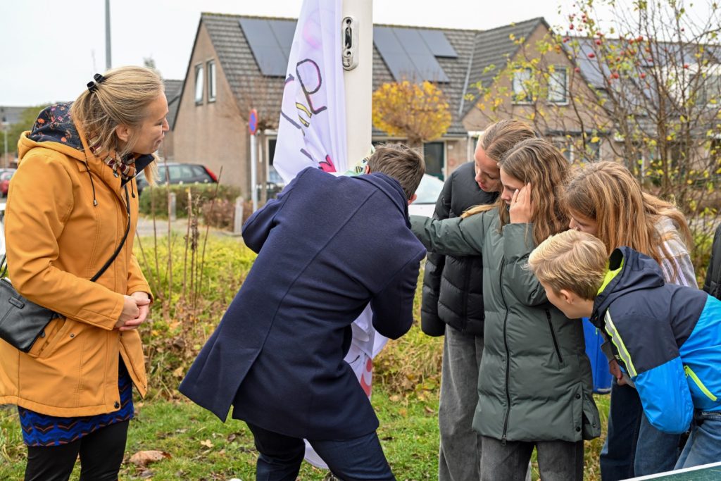 Met Lieke Mulder, klimaatburgemeester Stede Broec, leerlingen van de Willibrordschool maakt wethouder Thijs Visser de zelfgemaakte vlag los om te hijzen.