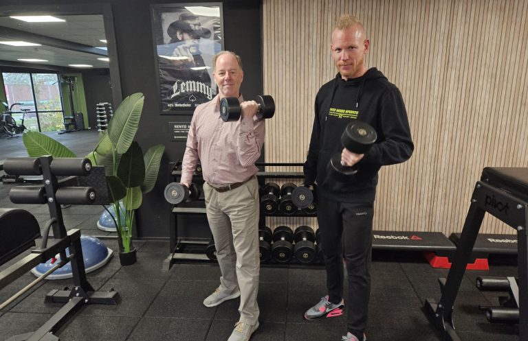 Wethouder Idso houdt samen met Koen Kramer, eigenaar Sento Modo Sport, gewichten vast.