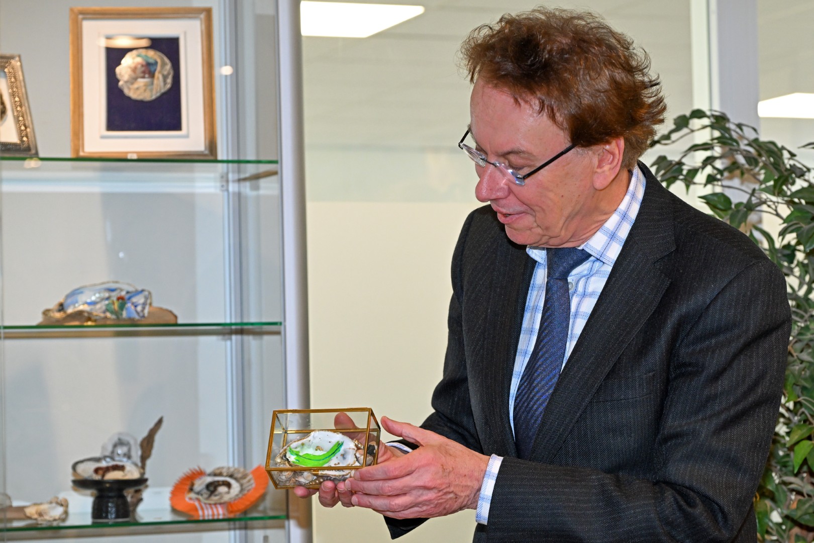 Burgemeester Ronald Wortelboer staat met een van de kunstwerken in zijn handen.