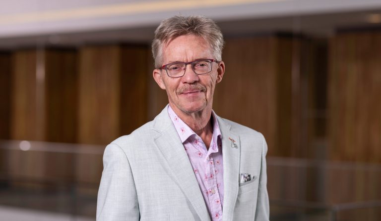 Wethouder Sjon Wagenaar in een portretfoto van zijn hoofd tot zijn middel in een pak.