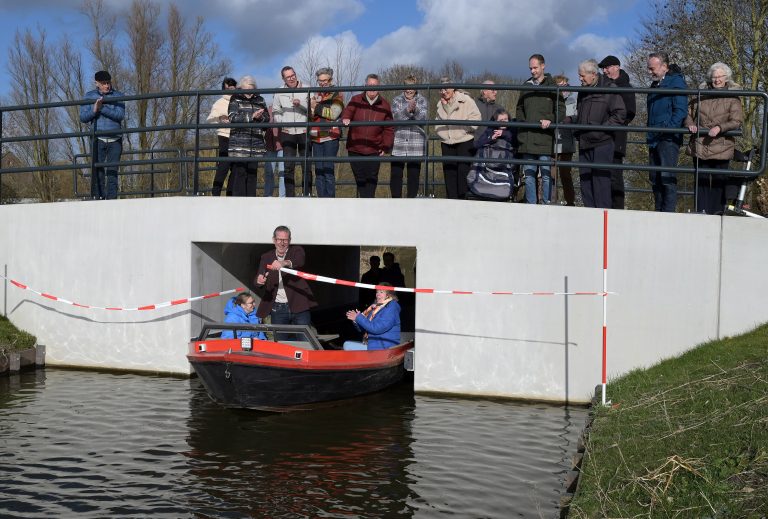 Vanaf een polderschuit knipt wethouder Nico Slagter het lint door bij de vaarduiker en maakte zo de doorvaart mogelijk naar de andere kant van de Parklaan.