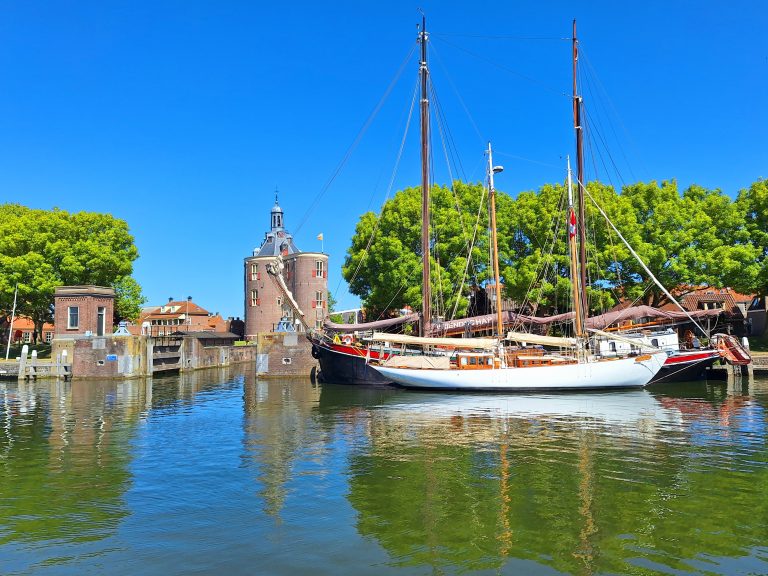Vanuit de haven van Enkhuizen een blik op de Drom. Op de voorgrond zien we een boot.